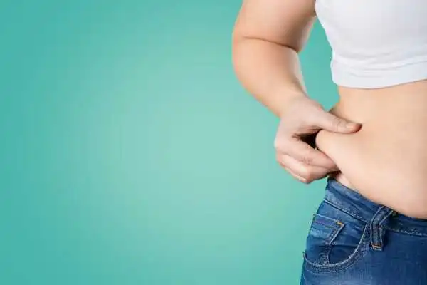 Image of woman pinching her love handles to show weight gain Leeds